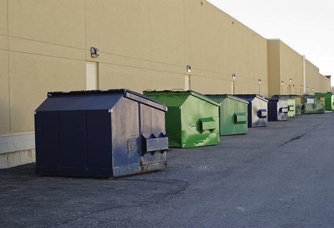 construction workers disposing of debris in large dumpsters in Dana